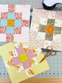 three quilt blocks with scissors on top of them next to each other and some fabric