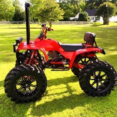 a red four - wheeler is parked in the grass