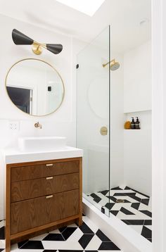 a bathroom with black and white tile flooring and a wooden cabinet in the corner