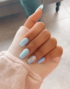 a woman's hand with blue nail polish and white flowers on it, holding onto her arm