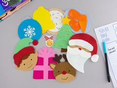 paper cutouts with santa claus, reindeer and snowflakes on top of a table