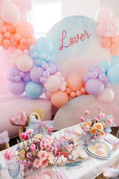 a table topped with lots of balloons and flowers