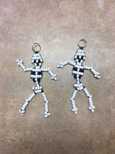 two white and black beaded keychains on concrete