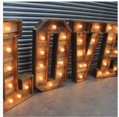 the word love is made out of wood and lit up with lights on it's sides