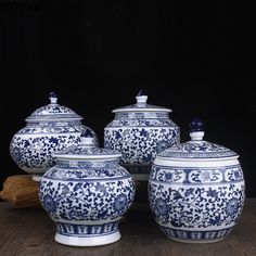 three blue and white vases sitting on top of a wooden table