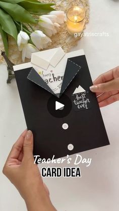 two hands are holding a card with the words teacher's day on it and an envelope