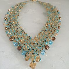 a multi stranded necklace with blue and gold beads on it's neckline