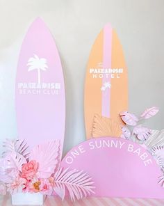 two surfboards are sitting on a table next to a vase with flowers in it