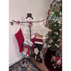 christmas stockings and stocking hangers in front of a tree with snowmen on it