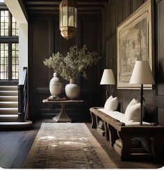 a room with two vases and lamps on the floor next to a table in front of a staircase