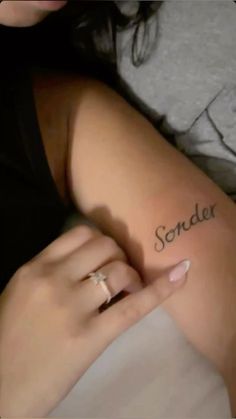 a woman laying in bed with her arm wrapped around the word'sonder '