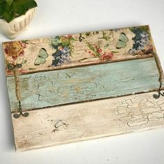 a piece of wood with flowers and butterflies painted on it