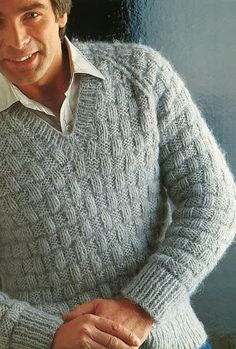 a man in a sweater is smiling for the camera