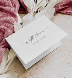 a white card with the word wife written on it next to some pink and white flowers