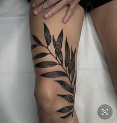 a woman's leg with black leaves on it