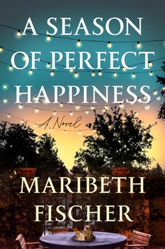 the cover of a season of perfect happiness by marbeth fischer, with string lights strung over an outdoor table and chairs