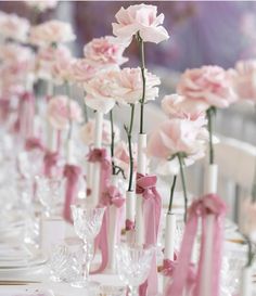 there are many pink flowers in vases on the table