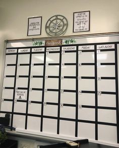 a white board with black lines on it in front of a clock and two pictures above it