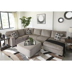 a living room with a sectional couch and ottoman