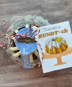 a jar filled with candles and a card on top of a wooden table that says thanks to bundt - t - ch