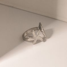 Embrace the spirit of summer with our Adjustable Stainless Steel Bohemian Beach Ring. Crafted to capture the essence of beachside freedom and boho chic, this ring features a unique, irregular design adorned with starfish and shell motifs. Perfect for beach parties, vacations, or just adding a touch of seaside magic to your everyday wear, this ring brings the ocean’s charm right to your fingertips. Product Features The Bohemian Beach Ring is designed with versatility and durability in mind. Its a Beach Summer Jewelry Ring, Summer Beach Jewelry Ring, Summer Beach Ring Jewelry, Starfish Jewelry For Vacation, Handmade Open Ring Jewelry For Beach, Summer Beach Metal Jewelry, Summer Vacation Starfish Jewelry, Summer Beach Midi Rings, Beach Metal Jewelry With Starfish Charm