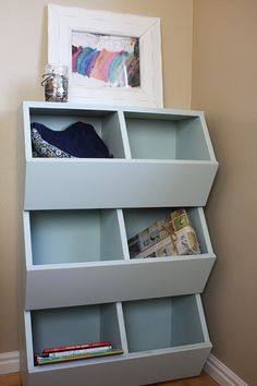 a book shelf with books and magazines on it in a corner next to a wall