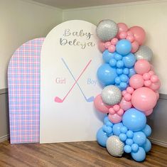 balloons and golf balls are arranged on the floor in front of a baby shower sign