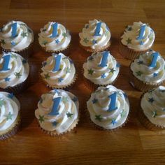 twelve cupcakes with white frosting and blue decorations