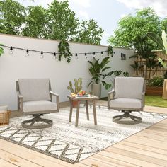 two chairs and a table on a rug in the middle of a patio with string lights