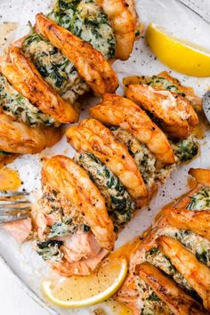 grilled chicken with spinach and lemons on a platter next to a fork