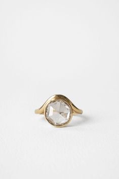 a gold ring with an oval white stone in the center