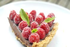 a piece of chocolate tart topped with raspberries