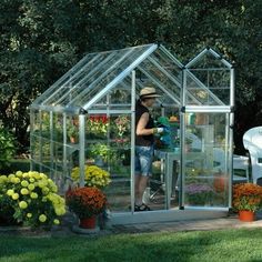 a man standing inside of a greenhouse with lots of flowers