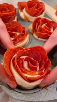 two hands are holding slices of pizza on a pan