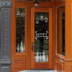 the front door of a building with glass and wood doors that say noel on it