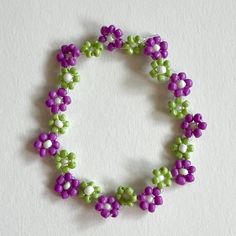 Green and purple flower in zigzag pattern. All bracelets are made with elastic nylon thread Adjustable Purple Bracelets For Spring, Handmade Purple Bohemian Stretch Bracelet, Green Purple Aesthetic, Handmade Purple Flower Beaded Bracelets, Purple Flower Bracelet, Adjustable Purple Flower Beaded Bracelets, Purple Green Aesthetic, Purple Beaded Flower Bracelets, Purple Flower Shaped Beaded Bracelets