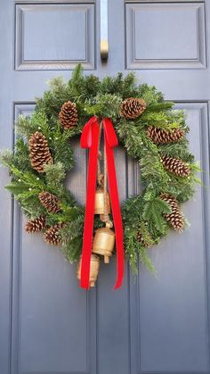 a christmas wreath with bells and pine cones hanging on the front door to give it a festive feel