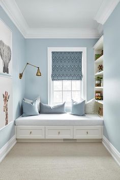 a window seat in the corner of a room with blue walls and white trim on the windowsill