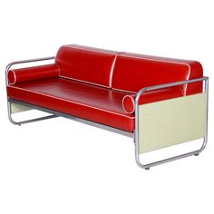 a red and white leather couch sitting on top of a metal frame with an armrest