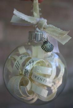 a glass ornament with ribbon and seashell on it