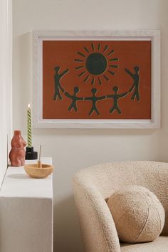 a living room scene with focus on the chair and artwork hanging above it's head