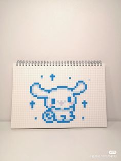 a white notebook with a pixellated image of a bull on the front and side