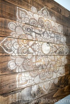 a wooden wall with white paint on it and an intricate design painted on the side