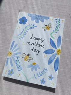 a mother's day card with blue flowers and bees