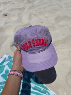 a purple hat with the word olee shodel on it is held up by a woman's hand