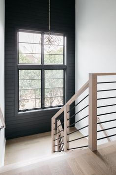 an empty room with black walls and wooden stairs