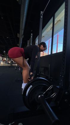 a woman is bent over on a gym machine