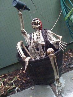 a skeleton sitting in a bucket with a hair dryer