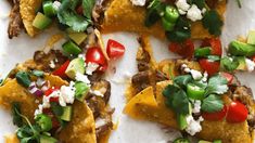 tortilla shells with meat, tomatoes, avocado and feta cheese