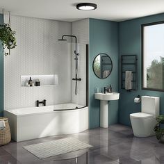 a bathroom with blue walls and white fixtures, including a tub, sink, toilet and shower